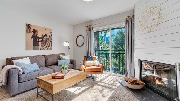 Un salon moderne avec un canapé, un fauteuil et une cheminée.
