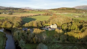 A castle surrounded by green fields and a river. - 4 bedroom accommodation in Newton Stewart (Newton Stewart)