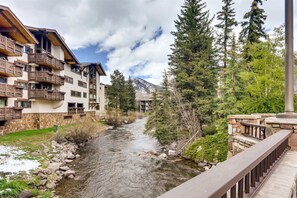 A river flowing through a mountainous area with wooden balconies and stone buildings. - 1-#42 4BD One Willow Bridge Road (Vail)