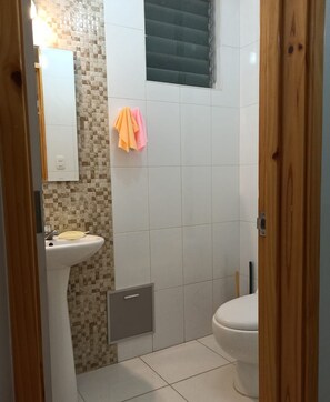 Ein Badezimmer mit Waschbecken, Toilette und Duschbereich.