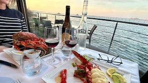 A dining table with seafood dishes, glasses of wine, and a scenic view of the sea. - Maison des dunes, panoramic sea view and waterfront - bikes, paddles (Plouescat)
