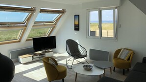 A modern living room with skylights, a flat-screen TV, and comfortable seating. - Maison des dunes, panoramic sea view and waterfront - bikes, paddles (Plouescat)