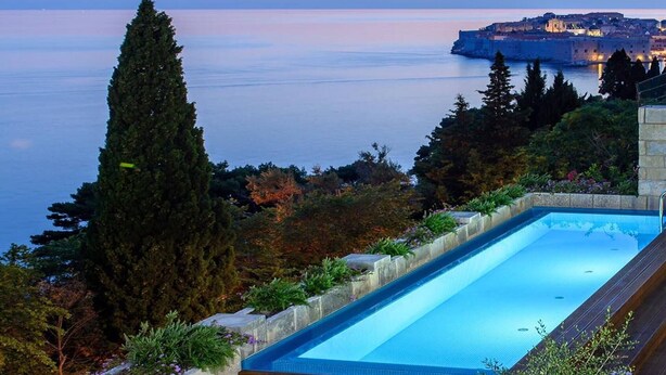 A swimming pool with a view of the sea and a distant cityscape. - Luxury Villa Castello Dubrovnik with Pool & Sauna (Dubrovnik)