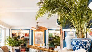A well-lit living room with a large bookshelf, a telescope, and a bowl of fruit on a coffee table. - Seafront Villa Dubrovnik Sea Diamant for 9 guests (Dubrovnik)