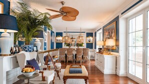 A spacious living room with a dining area, large windows, and a ceiling fan. - Seafront Villa Dubrovnik Sea Diamant for 9 guests (Dubrovnik)