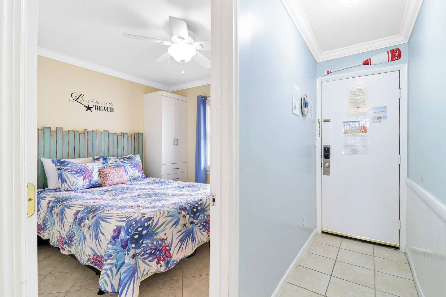 Une chambre à coucher avec un lit, un ventilateur de plafond et un mur orné d’une citation inspirante.