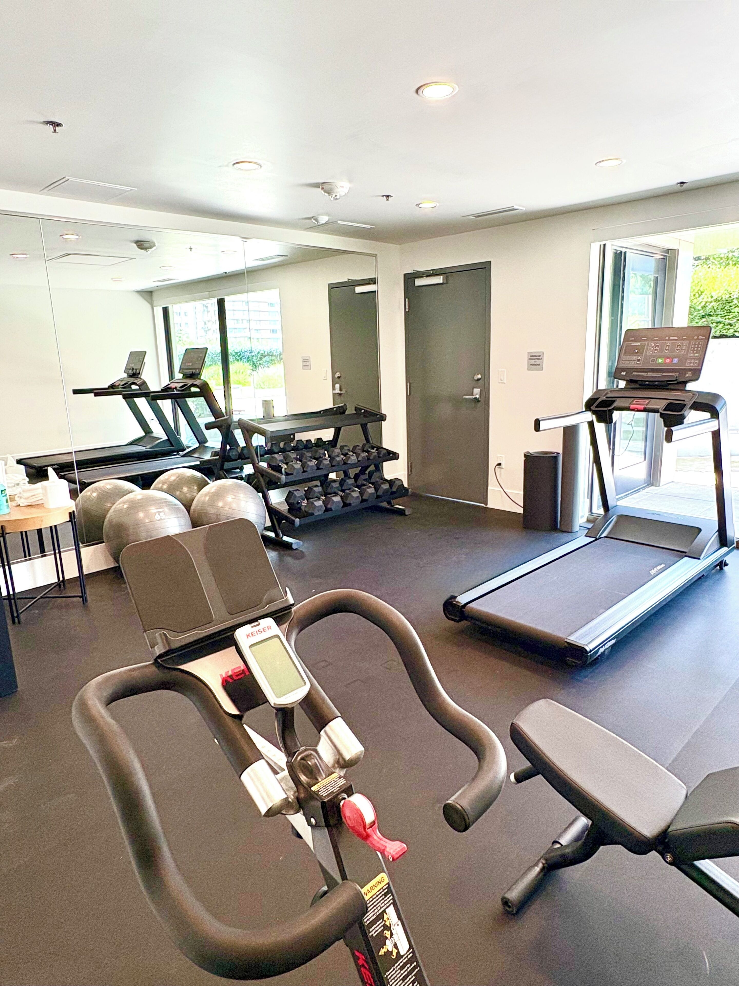 Un gimnasio con cintas de correr, pesas y equipamiento de ejercicio.