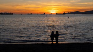 A sunset over a body of water with ships and silhouettes of people. - Revival English Bay, Vancouver  (Vancouver)