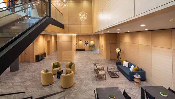 A spacious lobby with a herringbone floor, a staircase, and a seating area with sofas and chairs. - Revival English Bay, Vancouver  (Vancouver)