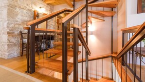A wooden staircase with metal railings in a room with stone walls and a wooden floor. - Luxury Seafront Villa Mare Orebic with Pool (Orebic)