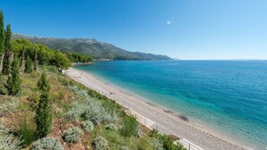 A coastal landscape with a beach, clear sky, and distant mountains. - Luxury Seafront Villa Mare Orebic with Pool (Orebic)