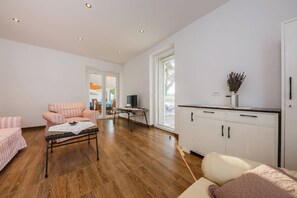Amplia sala de estar con un sofá, una mesa de centro y una cocina con armarios y una ventana.