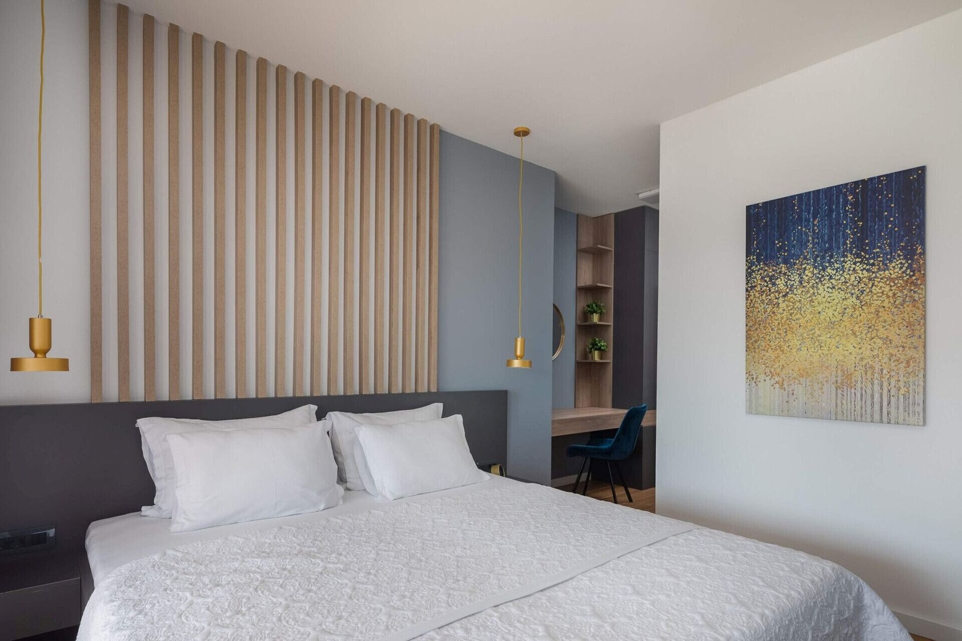 Ein modernes Schlafzimmer mit einem großen Bett, einer Wandgestaltung mit Lattenbrettern, einem Schreibtisch und einem Gemälde.