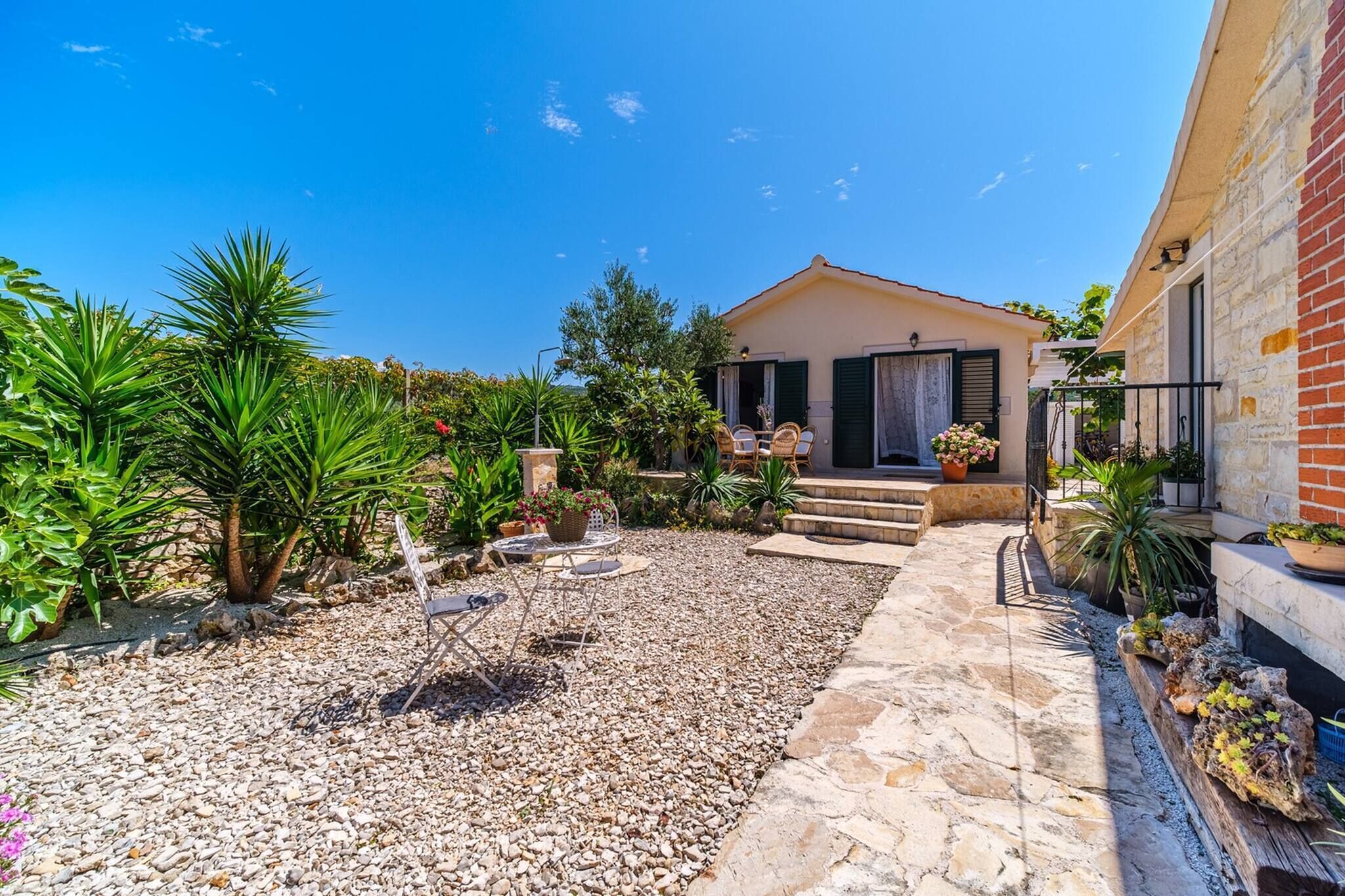 A courtyard with a stone pathway, outdoor furniture, and a building with a sloped roof.
