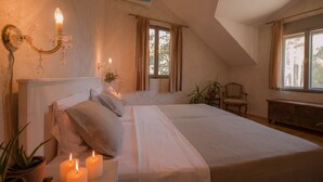 A bedroom with a large bed, a chandelier, a window with curtains, and a plant. - Luxury Villa Bol Oasis Brac With Heated Pool (Bol)