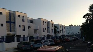 A modern building with a flat facade, multiple windows, and a central entrance. - Aguazul (Tías)