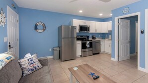 A compact living space with a kitchenette, a ceiling fan, and a blue wall.