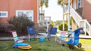 A patio area with lounge chairs, a small cooler, and a stroller.