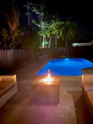 A pool area with a fire feature and outdoor furniture. - Family-Friendly 4BR with Pool & Game Room, 5 Mins to Beach! (Deerfield Beach)