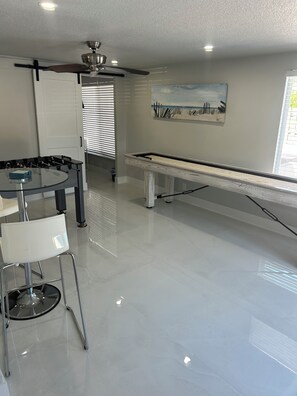 A modern kitchen with a dining area, a ceiling fan, and a painting on the wall. - Family-Friendly 4BR with Pool & Game Room, 5 Mins to Beach! (Deerfield Beach)