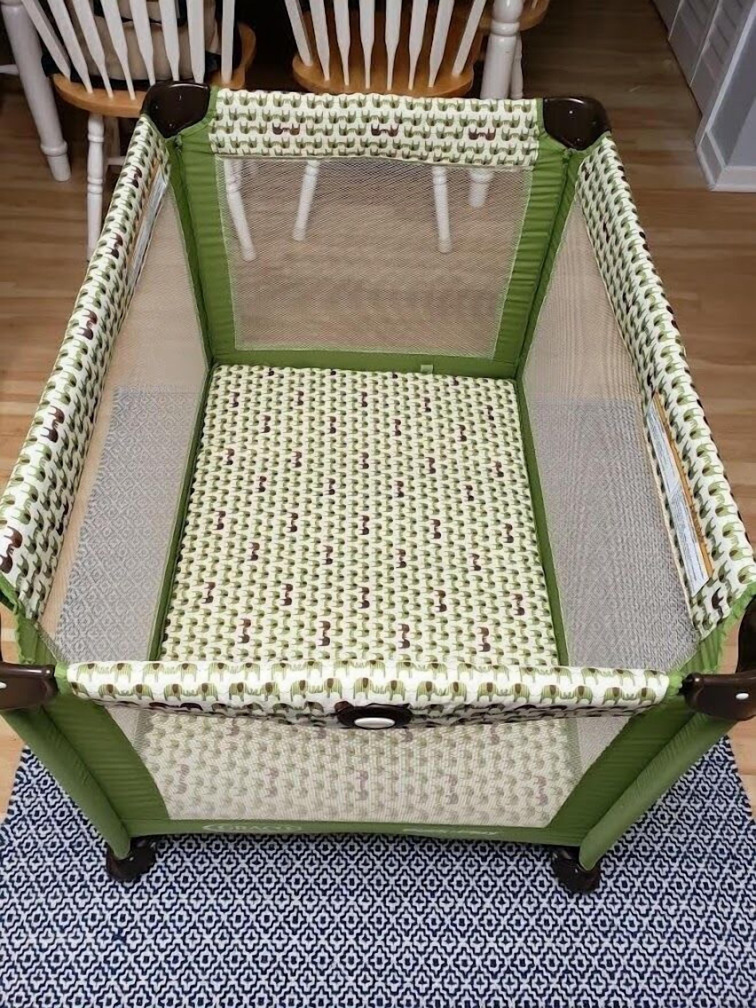 Uma cadeira verde com assento e encosto trançados, com uma almofada estampada.