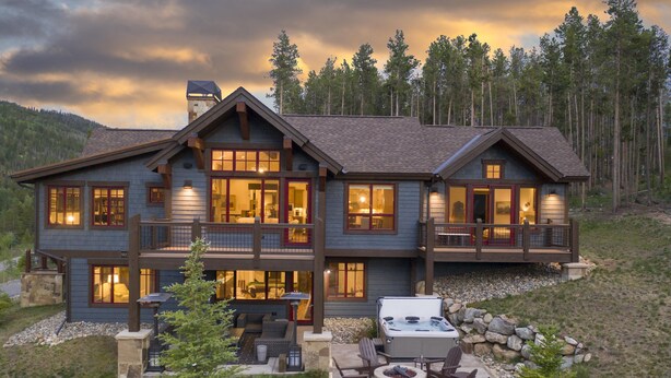 A large, two-story house with a balcony, a hot tub, and outdoor seating. - Spacious Elegance, 5 en suites, hiking trail to town, packed with amenities! (Breckenridge)