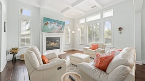 A spacious living room with a fireplace, white furniture, and large windows. - Luxury Family Resort Home Near Beach~ Pool ~ Hot Tub ~ Sportcourt (Encinitas)