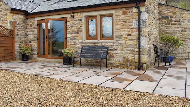 A stone house with a tiled roof, a bench, and a table with chairs outside. - Roosters Rest - UK31826 (Barley, near Clitheroe)