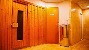 A hotel corridor with wooden doors, a private room sign, and a glass elevator.
