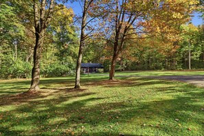 A park with a house, trees, and a well-maintained lawn.