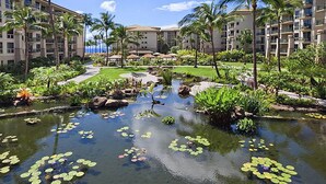 Ein Resort mit Wasserspiel, Palmen und Blick auf den Ozean.