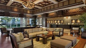 Eine geräumige Lobby mit hoher Decke, einem großen Kronleuchter und einer Sitzecke mit Sofas und Sesseln.
