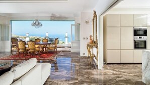 A modern interior with a dining area, a sofa, a marble floor, and a view of the sea. - Villa Stellare, with private pool and sea views (Capo d'Orlando)