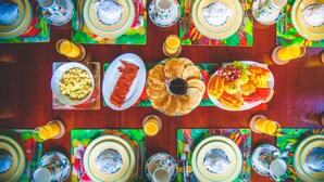 A dining table set with plates of food, utensils, and glasses. - A beautiful private beachfront paradise in Old Fort Bay, Ocho Rios (St. Ann Parish)