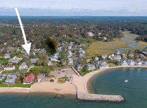 Stunning coastal views of a bustling beach and river, with houses featuring porches and modern designs.