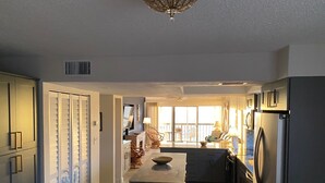 A modern kitchen with a central island, built-in appliances, and a view to the outside. - Renovated 2/2 Gulf Front Condo (Indian Shores)