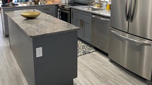 A modern kitchen with a central island, stainless steel appliances, and a contemporary design. - Renovated 2/2 Gulf Front Condo (Indian Shores)