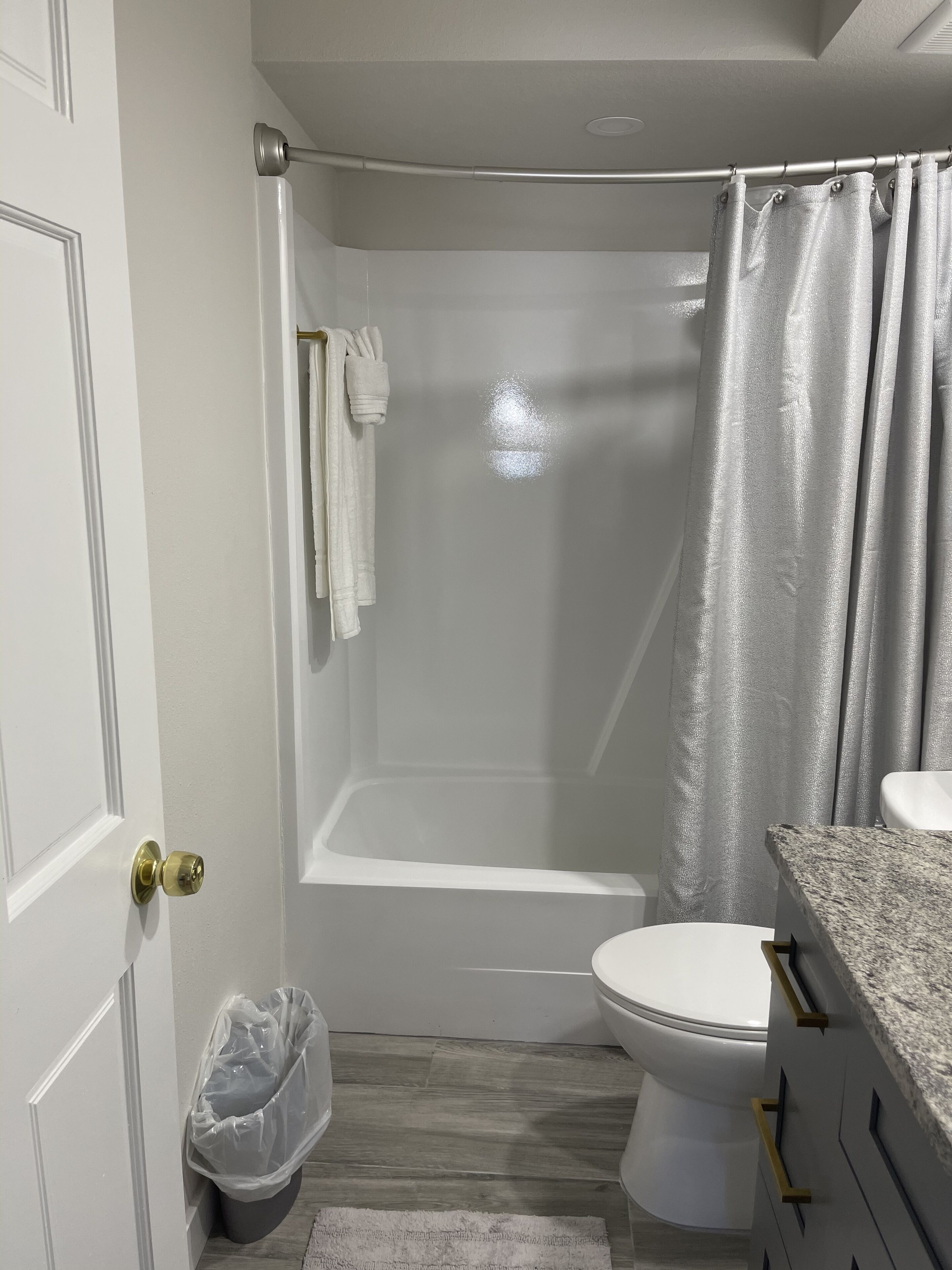 Een badkamer met een douche, toilet en wastafel.