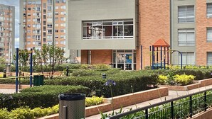 A modern building with a flat roof, large windows, and a brick facade. - WOW! NEW 3/2BR, NEAR AIRPORT & SHOPPING - PREMIUM! (Bogotá)