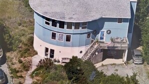 A multi-story building with a curved roof, situated near a body of water. - Family friendly home w/  360 views of the bay and wild life preserve (Milton)