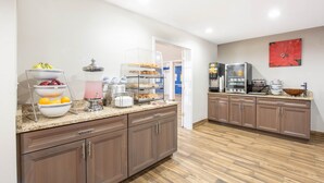A modern kitchen with a granite countertop, wooden cabinets, and a breakfast bar. - Microtel Inn&Suites by Wyndham (Springfield)