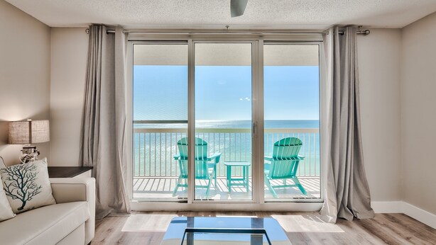 A room with a sliding glass door leading to a balcony with a view of the ocean. - Gulf Front, Renovated unit in Pelican Beach Resort, Wi-Fi, Cable (Destin)