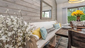 A wooden wall, a white sofa with pillows, a dining table with plates, and a vase with flowers. - 2 Bedroom +Loft, 2 bath townhouse in The Galena Territory (Galena)