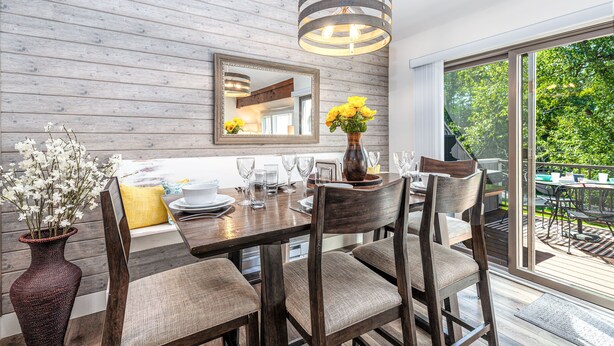 A dining area with a wooden table, chairs, a vase with flowers, and a hanging light fixture. - 2 Bedroom +Loft, 2 bath townhouse in The Galena Territory (Galena)