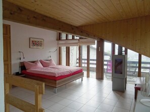 A bedroom with a bed, a television, and a large window. - Am Dürrbach 5/545 Appartement/Fewo 4-Bettwohnung by Interhome (Engelberg)
