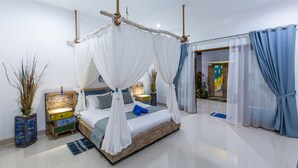 A modern bedroom with a wooden bed, white canopy, and blue curtains. - MasBro ART Villas (Seminyak)