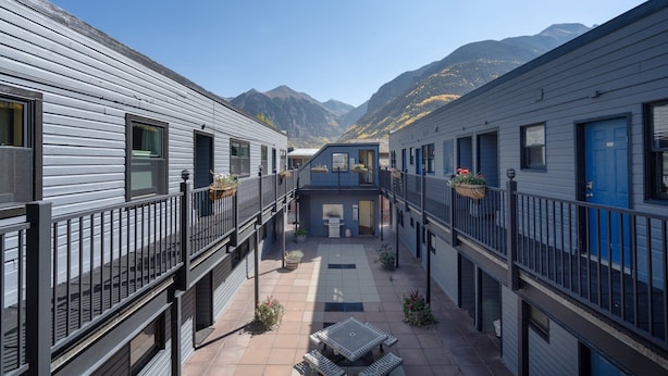 A courtyard with a central seating area, surrounded by buildings with balconies and windows. - Modern Mid-Town Hideaway, Steps to Gondola, Walk Anywhere (Telluride)
