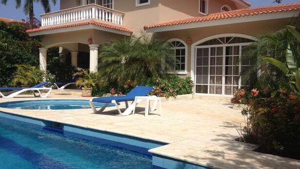 A poolside area with lounge chairs and a swimming pool.