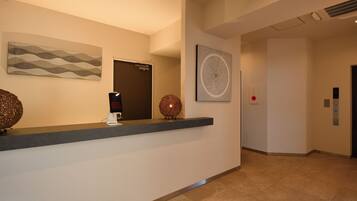 Un área de recepción con mostrador, una puerta y una cámara de seguridad instalada en la pared.