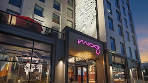 Un bâtiment moderne avec une enseigne au néon indiquant « mozy » à l’entrée.